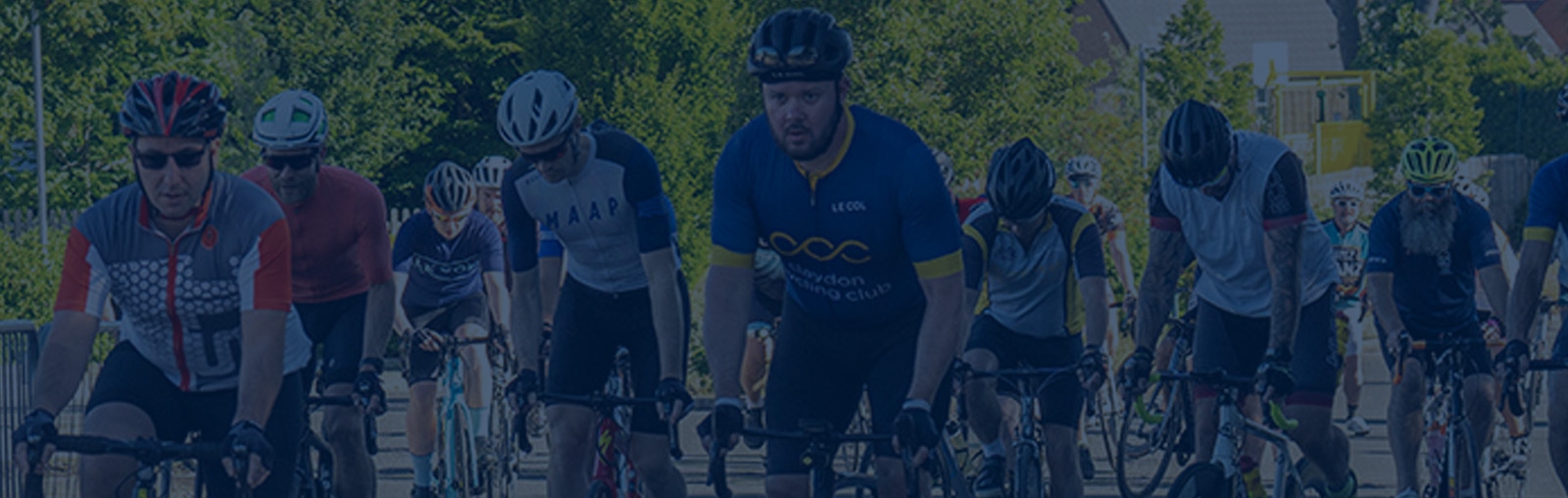 Cyclists starting a sportive. They are cycling under an inflatable arch.