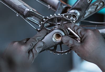 A mechanic working on a bicycle chainring