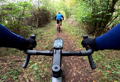 View from a cyclist riding along a wooded trail